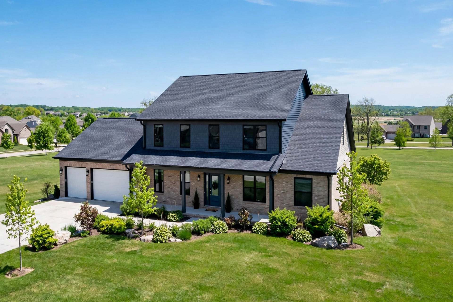 Completed shingle roof replacement on a suburban home photographed in daylight