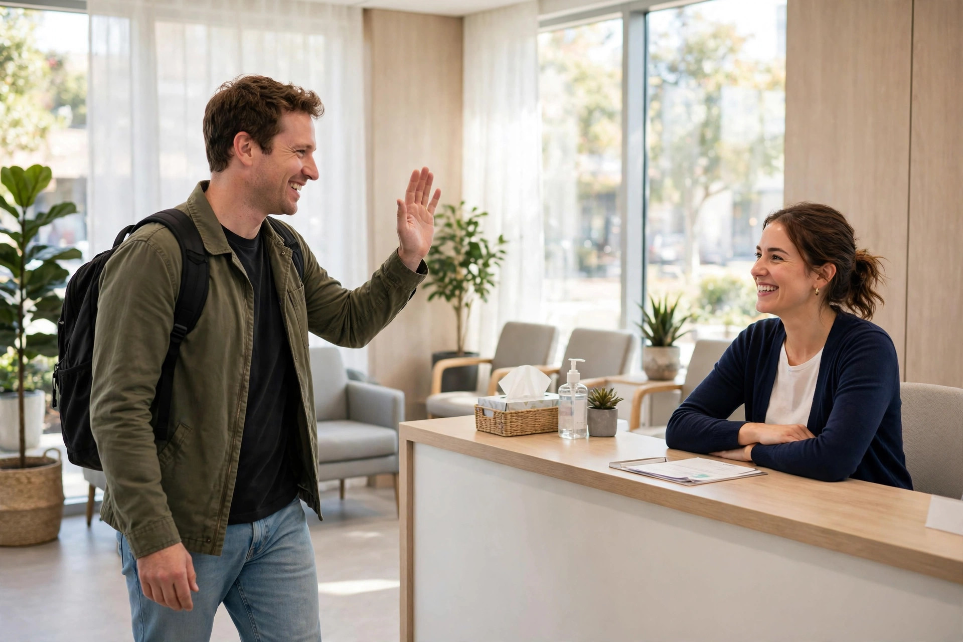 Happy patient waving goodbye to the smiling receptionist at a dental office front desk